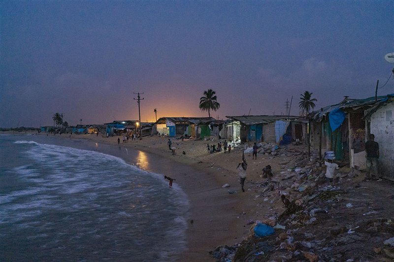 El crepúsculo envuelve este distrito a orillas del Atlántico. La población de esta depauperada comunidad de Monrovia vive hacinada y sin saneamiento ni servicios básicos.