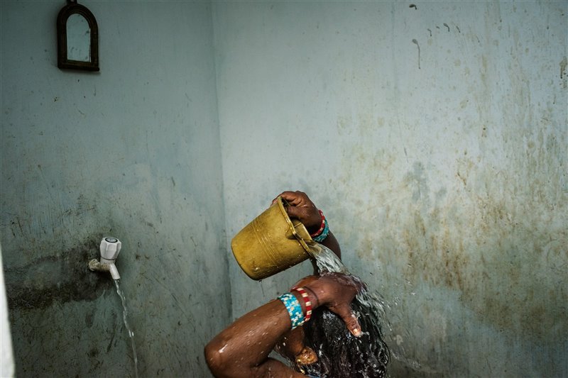 Una mujer se baña en la periferia de Bhubaneshwar, una ciudad del estado indio de Odisha, en el este del país. La mayoría de los hogares urbanos de la India –y el 82 % de las casas rurales– no tiene agua corriente.