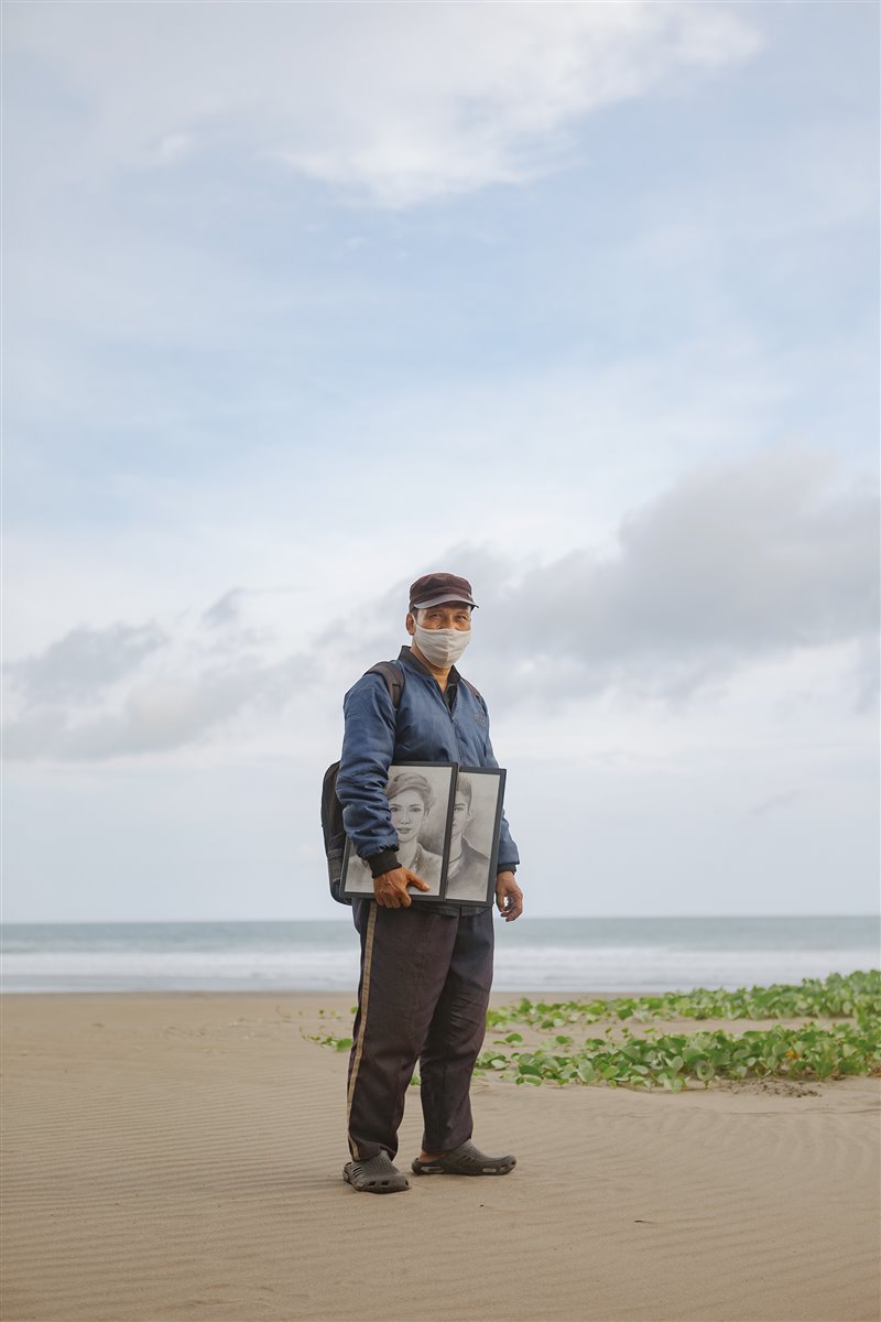 El retratista Sigit Parwanto, con algunos de sus trabajos bajo  el brazo, vivía de los encargos de los turistas que llenaban la playa javanesa de Parangtritis… hasta la pasada  primavera, cuando dejaron de llegar.