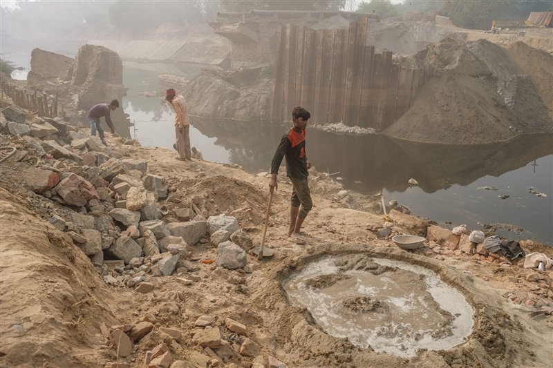 La niebla flota en el aire mientras unos hombres trabajan en el proyecto de una presa en Faridabad, cerca de Delhi. Nueve de las diez ciudades más contaminadas del mundo están en la India. Se calcula que en 2019 murieron prematuramente en este país 1,7 millones de personas a causa de la contaminación.