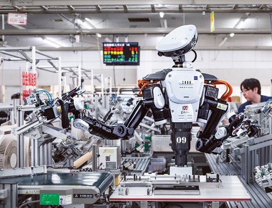 Pound, un robot fabricado por Kawada Robotics, ayuda a montar dispensadores de cambio en una fábrica de Glory en la ciudad japonesa de Kazo. Cada robot forma parte de un equipo humano-robótico que colabora para construir el producto.