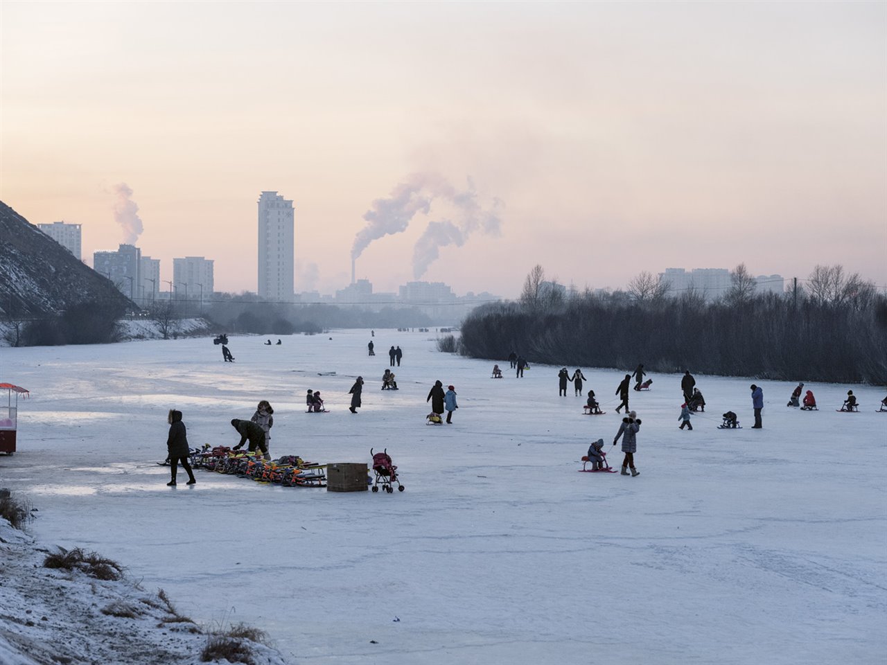 La gente juega sobre el hielo del río Tuul, al sur de Ulan Bator, frente a un telón de fondo que dibuja el aire contaminado de la ciudad. La combustión de carbón en hogares y centrales eléctricas convierte a la capital de Mongolia en una de las más contaminadas del planeta. 