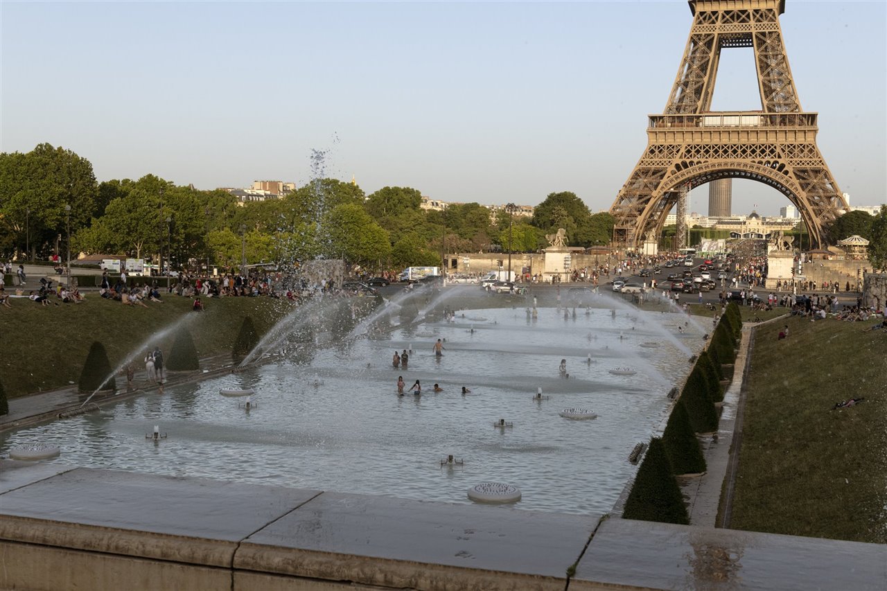 En 2019 se registraron récords térmicos en seis países de la Europa occidental, entre ellos los 46 ºC de Francia. En la imagen decenas de personas se refrescan en las fuentes instaladas frente a la Torre Eiffel ese mismo año.