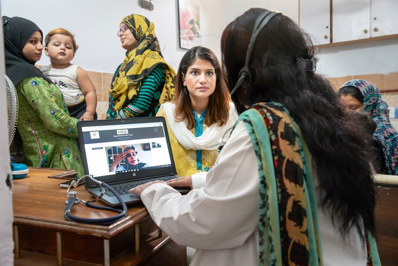 Sara Saeed observa cómo una de sus colaboradoras, la enfermera Tabinda Bibi, atiende una consulta telemática en el Centro Médico de Tayyab, en Karachi, una de las e-clínicas de su organización.