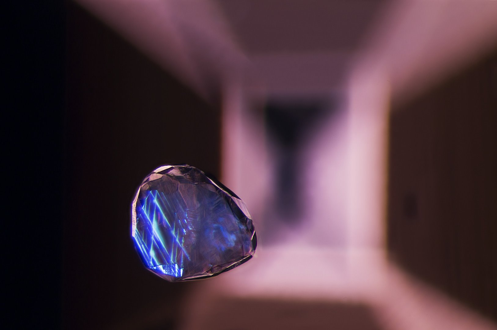 Inclusión de cristal de calcita suspendido en una piedra preciosa de espinela