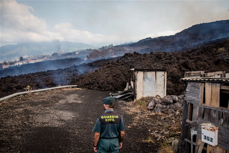 Un agente de la Guardia Civil observa la colada de lava a su paso por una de las vías de comunicación de La Palma.
