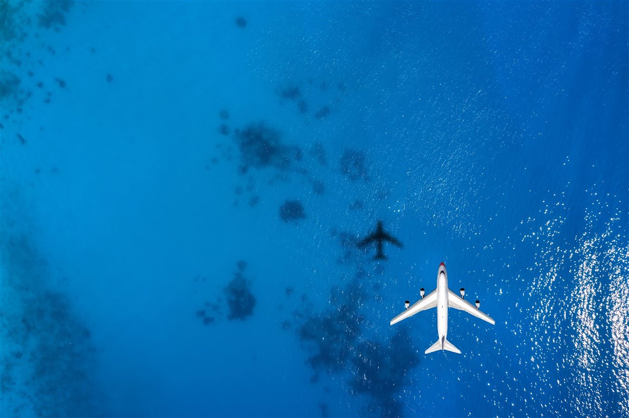 Vista cenital de un avión volando sobre el mar