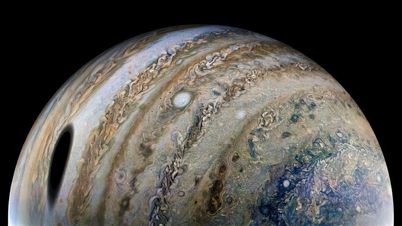 Imagen de Jupiter capturada por la sonda Juno el 25 de febrero de 2022. La gran sombra oscura a la izquierda de la imagen fue proyectada por la luna de Júpiter, Ganímedes.