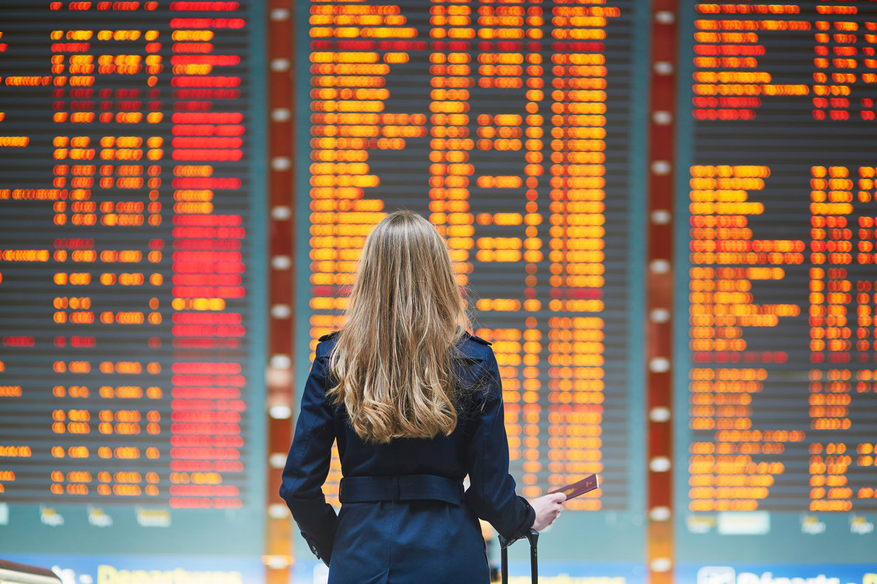 Una mujer comprueba la información de su vuelo en el panel de un aeropuerto