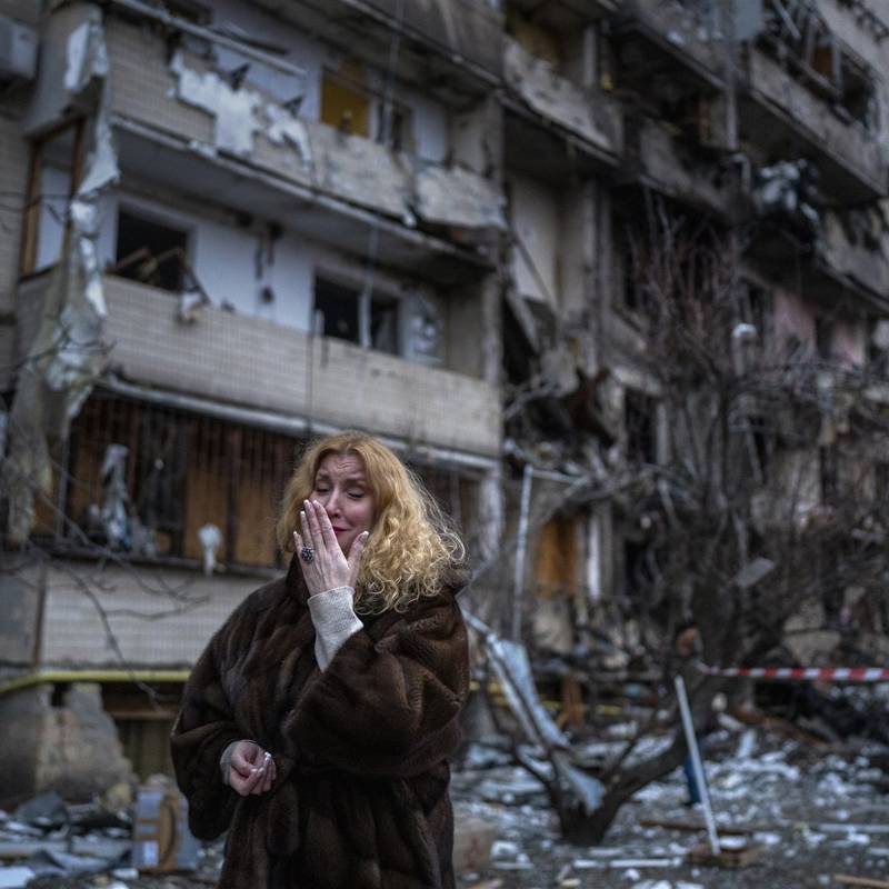 Una ciudadana ucraniana llora desconsolada junto a su casa después de un ataque con misiles en la ciudad de Kiev, Ucrania, el viernes 25 de febrero de 202