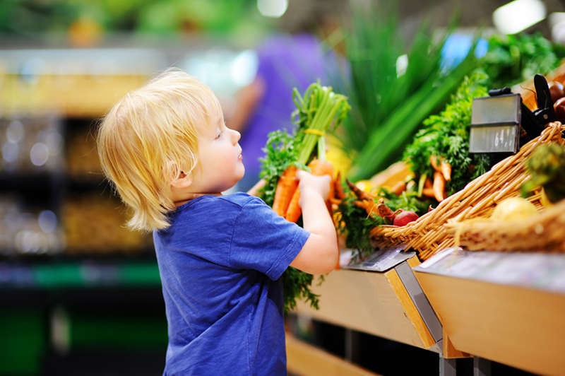 Niño con verdura en supermercado