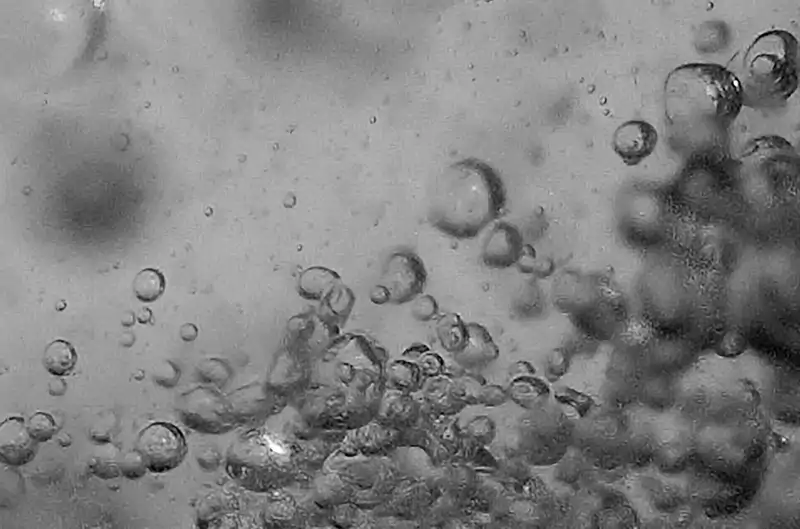 En una instalaci&#243;n experimental, las c&#225;maras de alta velocidad capturaron flashes de microluz (en el centro inferior) que se produc&#237;an entre aire microsc&#243;pico y burbujas de metano en el agua. 
